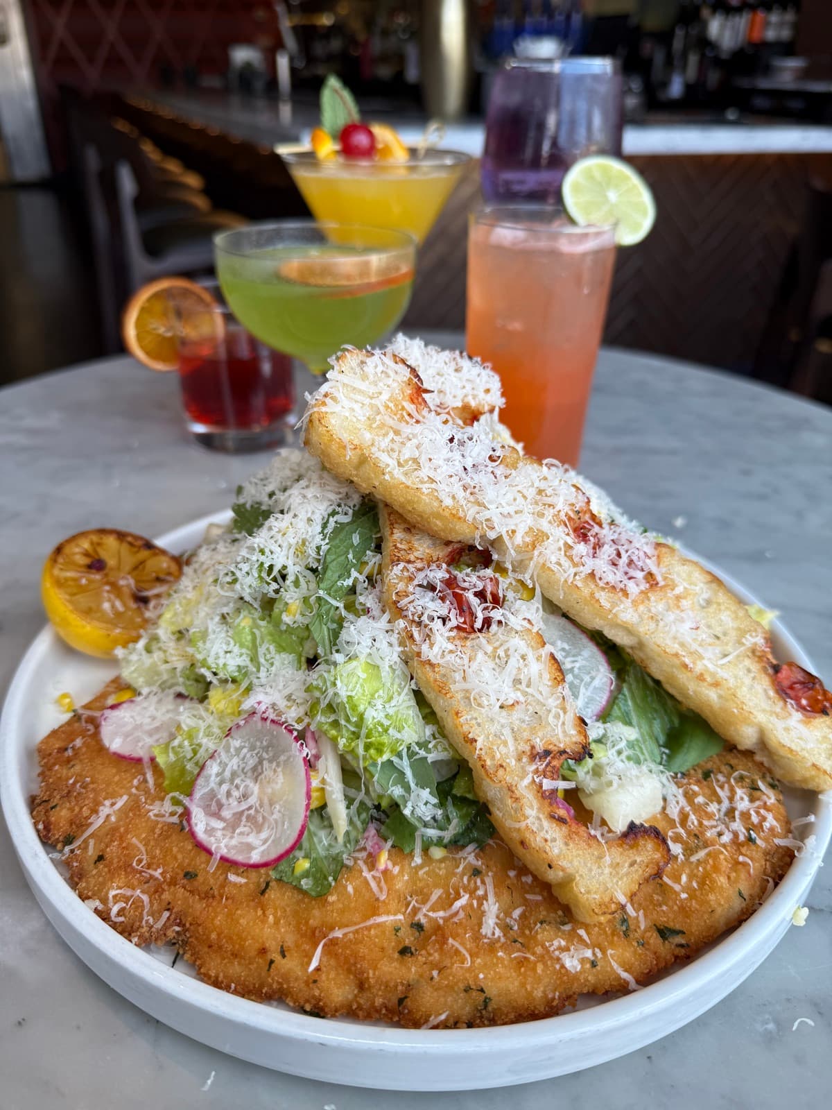 Chicken milanese with Caesar salad and cocktails